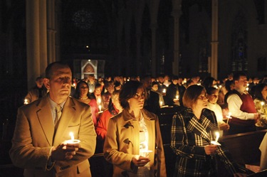 Katie Jarocki, of Bridgewater, Mass., center, stands with her parents Mark, left, and Nancy Jarocki, right, during an Easter vigil with Cardinal Sean P. O'Malley at the Cathedral of the Holy Cross in Boston, Saturday, April 11, 2009. Her parents were visiting for the holiday. (Photo/Lisa Poole)