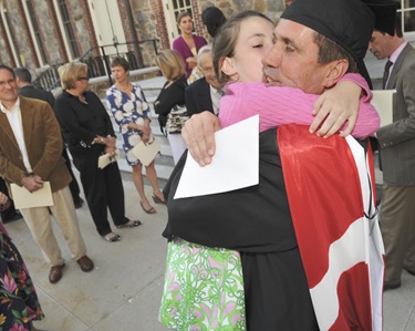 Graduate Craig Gibson, of Winchester, Mass., gets a hug from his daughter Caroline Gibson, 11, after commencement of Master of Arts in Ministry at St. John's Chapel at St. John's Seminary, Wednesday, May 20, 2009 in Brighton, Mass. (Photo by Lisa Poole)