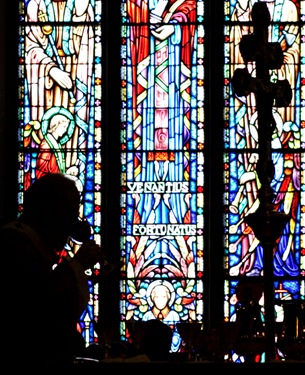 Archbishop O'Malley is silhouetted against the stained glass windows of the Cathedral as he celebrates the Eucharist.  Pilot photo by Gregory L. Tracy