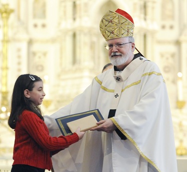 Cardinal Sean O'Malley gives Michelle Beazley the Blessed Mother Teresa of Calcutta award during an altar server appreciation mass at the Cathedral of the Holy Cross, Boston, Saturday, Oct. 31, 2009. (Photo/Lisa Poole)