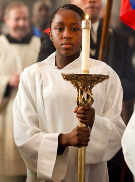 Nicole Audate of St. Angela Parish in Mattapan carries a candle in the openning procession. Cardinal Seán P. O’Malley celebrates a memorial Mass at the Cathedral of the Holy Cross March 7, 2010 for the victims of the Jan. 12 earthquake in Haiti. Pilot photo by Gregory L. Tracy