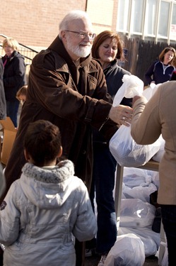 Cardinal Sean P. O'Malley, left, and Deborah Kincade Rambo, President, Catholic Chariities of the Archdiocese of Boston,  help distribute turkeys during the Thanksgiving Project at the Catholic Charities Yawkey Center in Dorchester on Saturday, December 17, 2012. The Thanksgiving Project was a collaboration between the United Way of Massacusetts Bay and Merrimack Valley to provide Thanksgiving Meals to 7,000 families this holiday. Catholic Charities distributed over 3,000 of the meals at their sites. (Photo by Suzanne Ouellette/Catholic Charities)