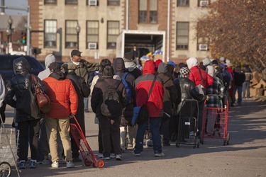 People line up to receive turkeys during the Thanksgiving Project outside Catholic Charities El Centro del Cardenal Food Pantry in Boston's South End on Saturday, December 17, 2012. The Thanksgiving Project was a collaboration between the United Way of Massacusetts Bay and Merrimack Valley to provide Thanksgiving Meals to 7,000 families this holiday. Catholic Charities distributed over 3,000 of the meals at their sites. (Photo by Suzanne Ouellette/Catholic Charities)