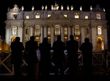 Six men pray the rosary in Spanish in front of St. Peter's Basilica Feb. 28, minutes after the period of Sede Vacante began.  Pilot photo/Gregory L.  Tracy