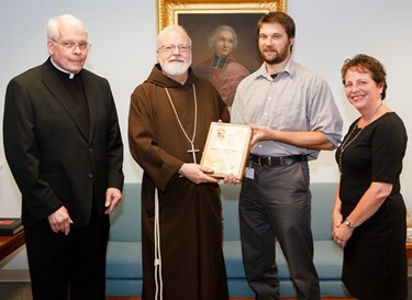 Pilot staff reporter Christopher S. Pineo receives his plaque of the Pontifical Mission Societies’ Archbishop Edward T. O’Meara Award from Cardinal Seán P. O'Malley Aug. 13, 2014. Pineo took first place in the category of Mission Animation News for his Aug. 30, 2013 story “Plymouth Religious Ed Students Use Lemonade Stand to Spread the Good News.” First presented in 1993, the award recognizes excellence in coverage of world mission news in the Catholic press.<br />
Pilot photo/ Gregory L. Tracy<br />
