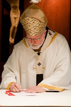 Cardinal Seán P. O'Malley formally accepts Father Garcia Brenneville as a priest of the Archdiocese of Boston in a ritual known as incardination at the archdiocese’s Pastoral Center April 7, 2015.  Father Brenneville is a native of Port-Au-Prince, Haiti, and he serves as parochial vicar at Christ the King Parish, St. Edith Stein Parish and Our Lady of Lourdes Parish in Brockton.  (Pilot photo/ Gregory L. Tracy)