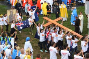 Pilgrims from Australia carry the World Youth Day cross during the opening Mass July 26 at Blonia Park in Krakow, Poland. (CNS photo/Bob Roller) See WYD-OPEN-BLONIA-MASS July 26, 2016.