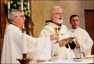 Bishops-elect Robert Reed and Mark O’Connell take their Oath of Fidelity before Cardinal O’Malley during a Mass broadcast live on CatholicTV Aug. 12, 2016. During the Mass, the cardinal also blessed the insignia — crossiers, mitres and rings — that the bishops will receive at their ordination.
Pilot photo/ Gregory L. Tracy 
