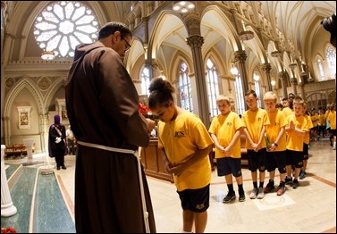 Students from the parish school of Immaculate Conception Parish in Lowell, Mass. venerate the relic of the heart of St. Padre Pio Sept 21, 2016. Their parish was the first stop of a three-day visit of the relic to Boston. Pilot photo/ Gregory L. Tracy 